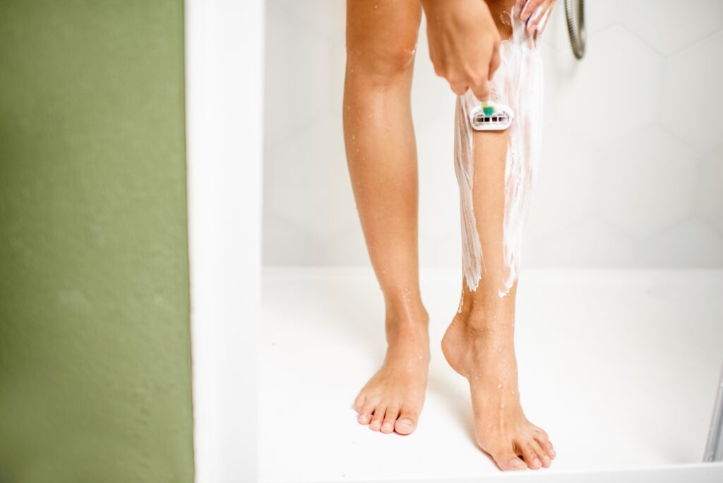 Kobieta goli nogi pod prysznicem 